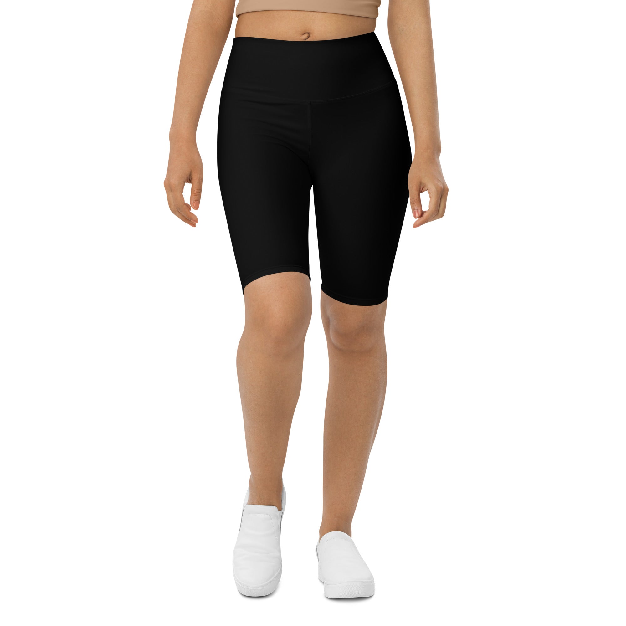 A woman standing wearing black biker shorts.