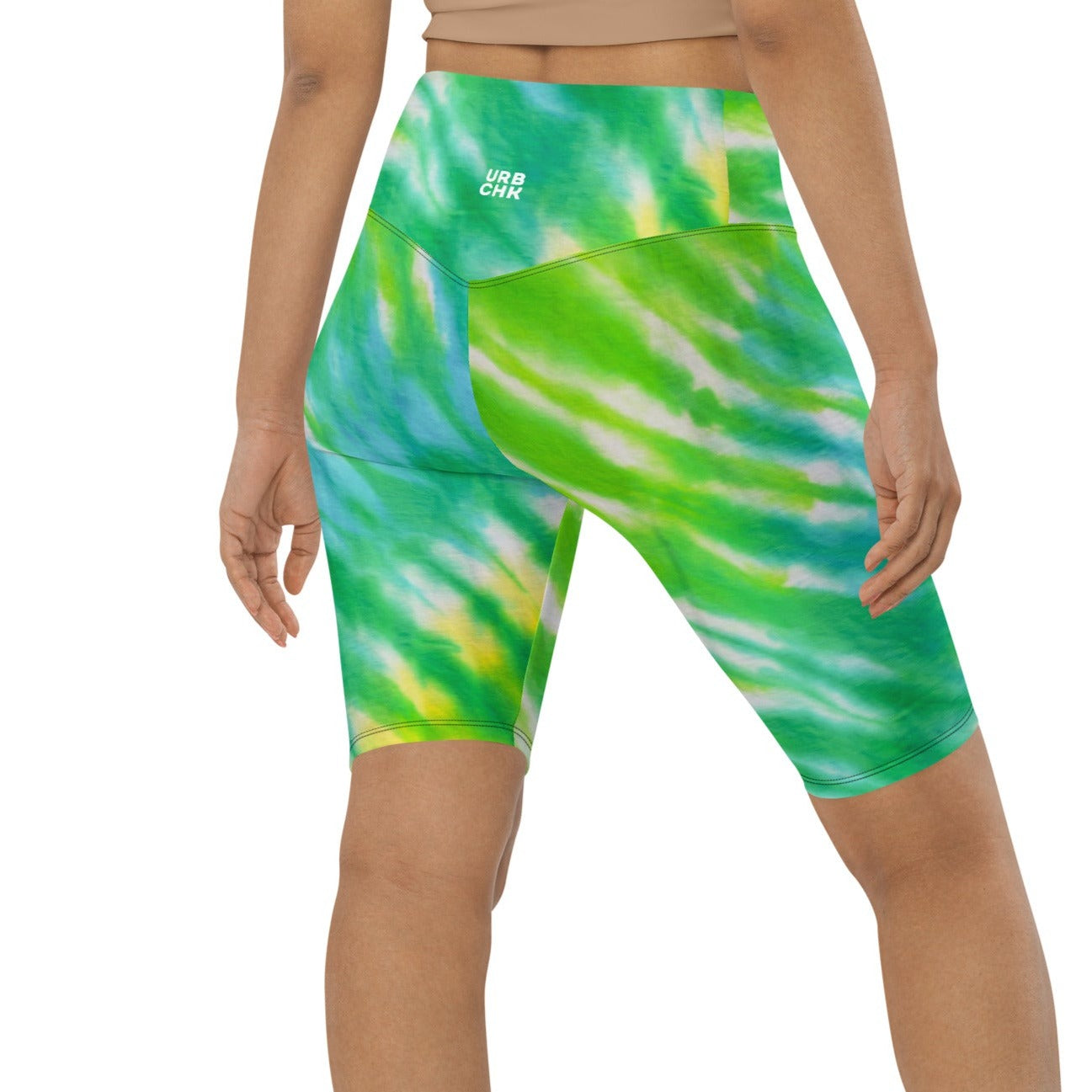 A woman standing wearing green biker shorts.