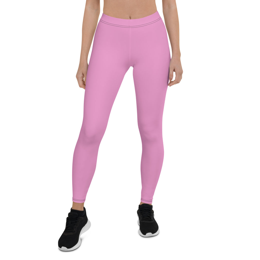 A pair of pink mid-rise active leggings, shown from the waist to the mid-section, featuring a four-way stretch fabric and an elastic waistband.