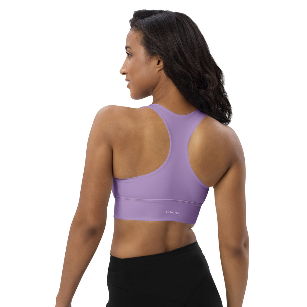 A woman wearing a purple longline sports bra with double-layered front straps and mesh lining.