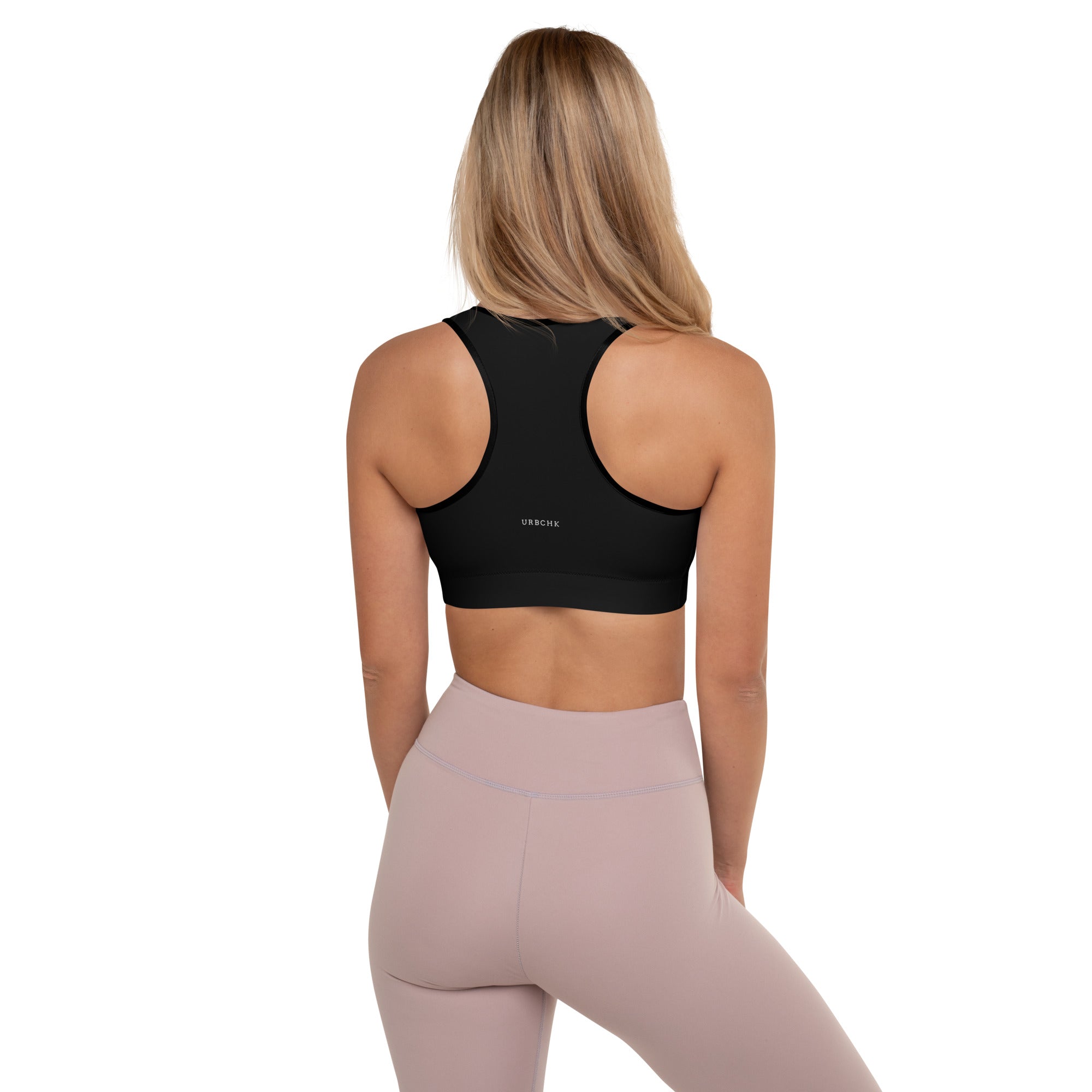 A women wearing a black padded sports bra with white background.