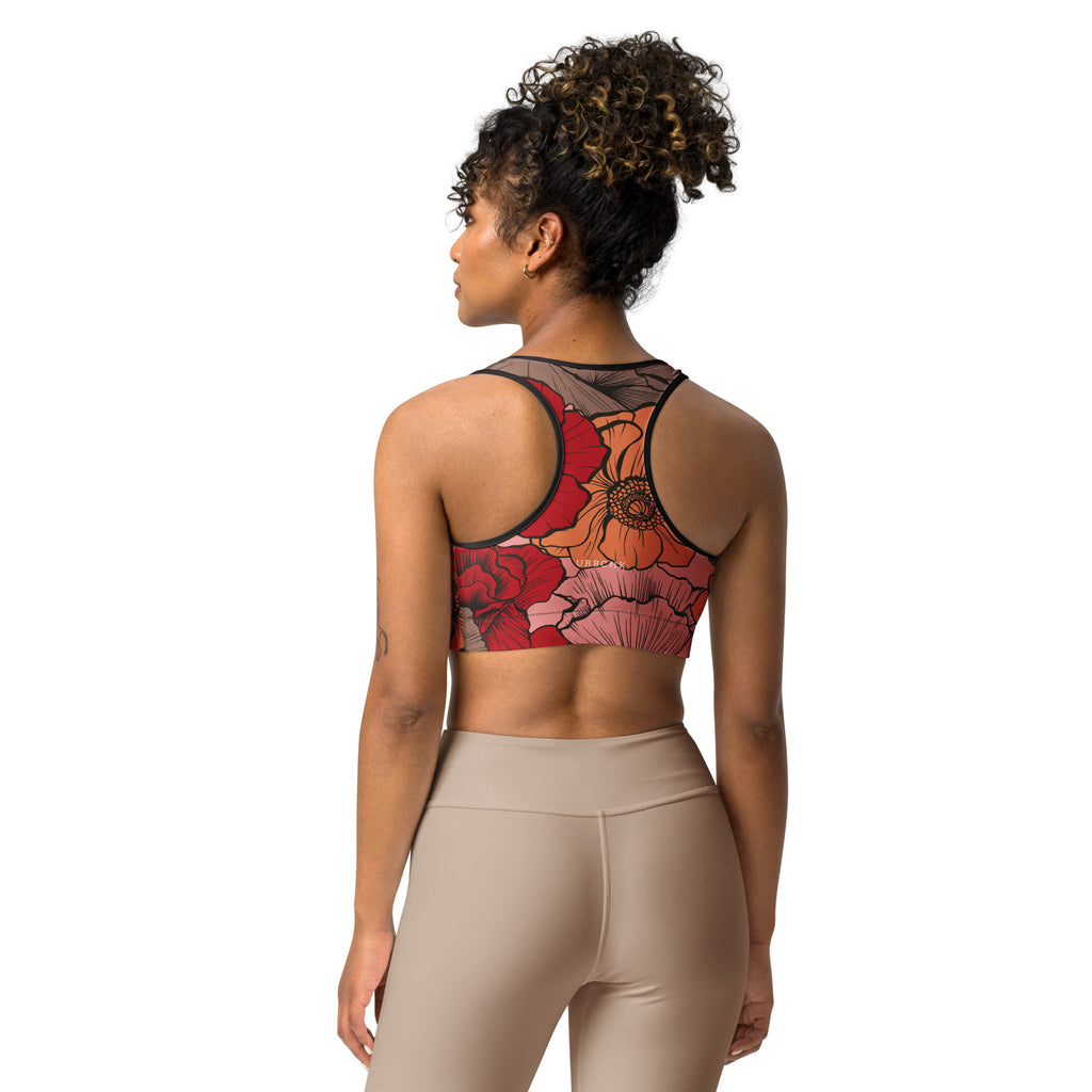 A woman wearing a sports bra with a multicolored floral design in the front and solid beige color on the sides.