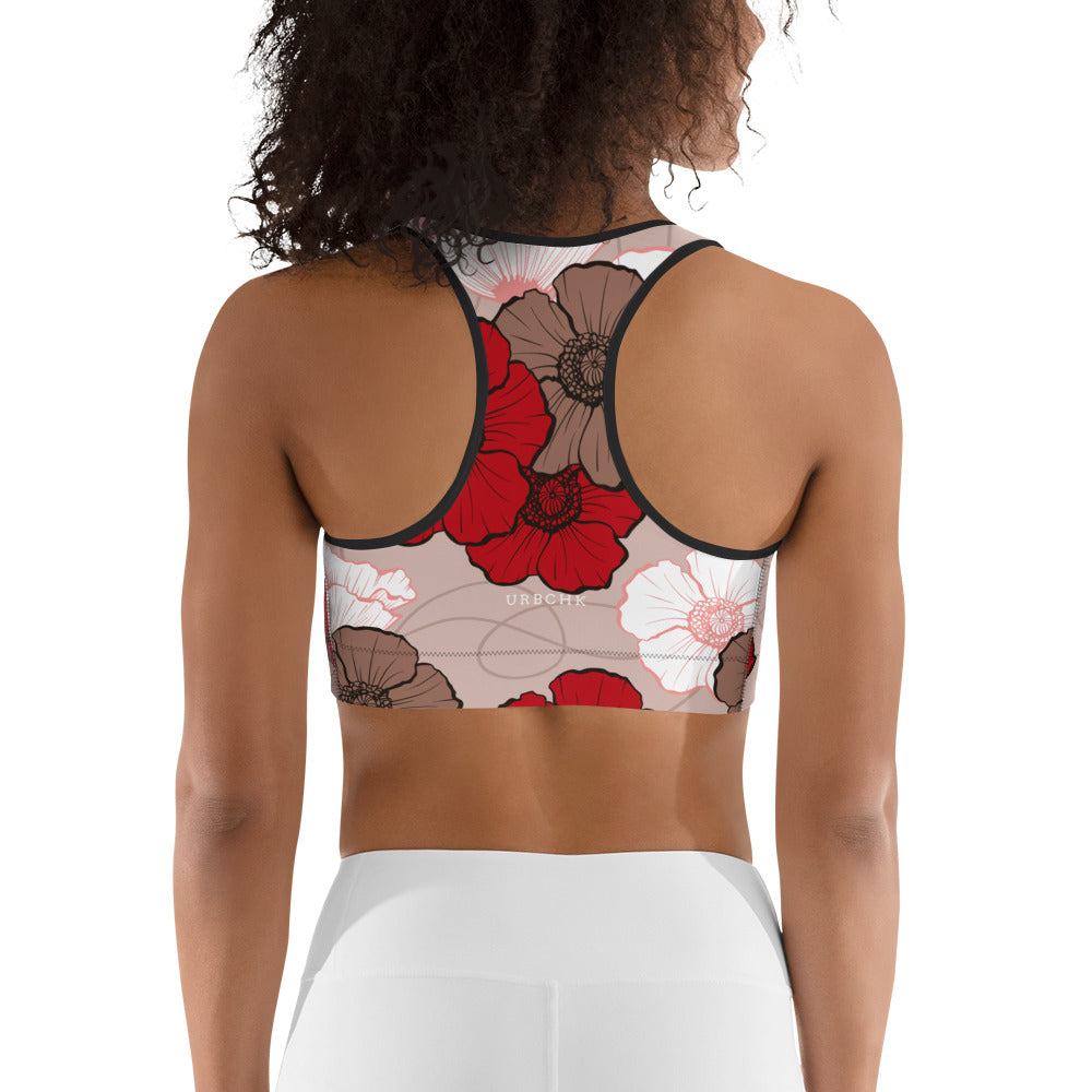 A sports bra with a floral pattern in shades of red and white, viewed from the back.