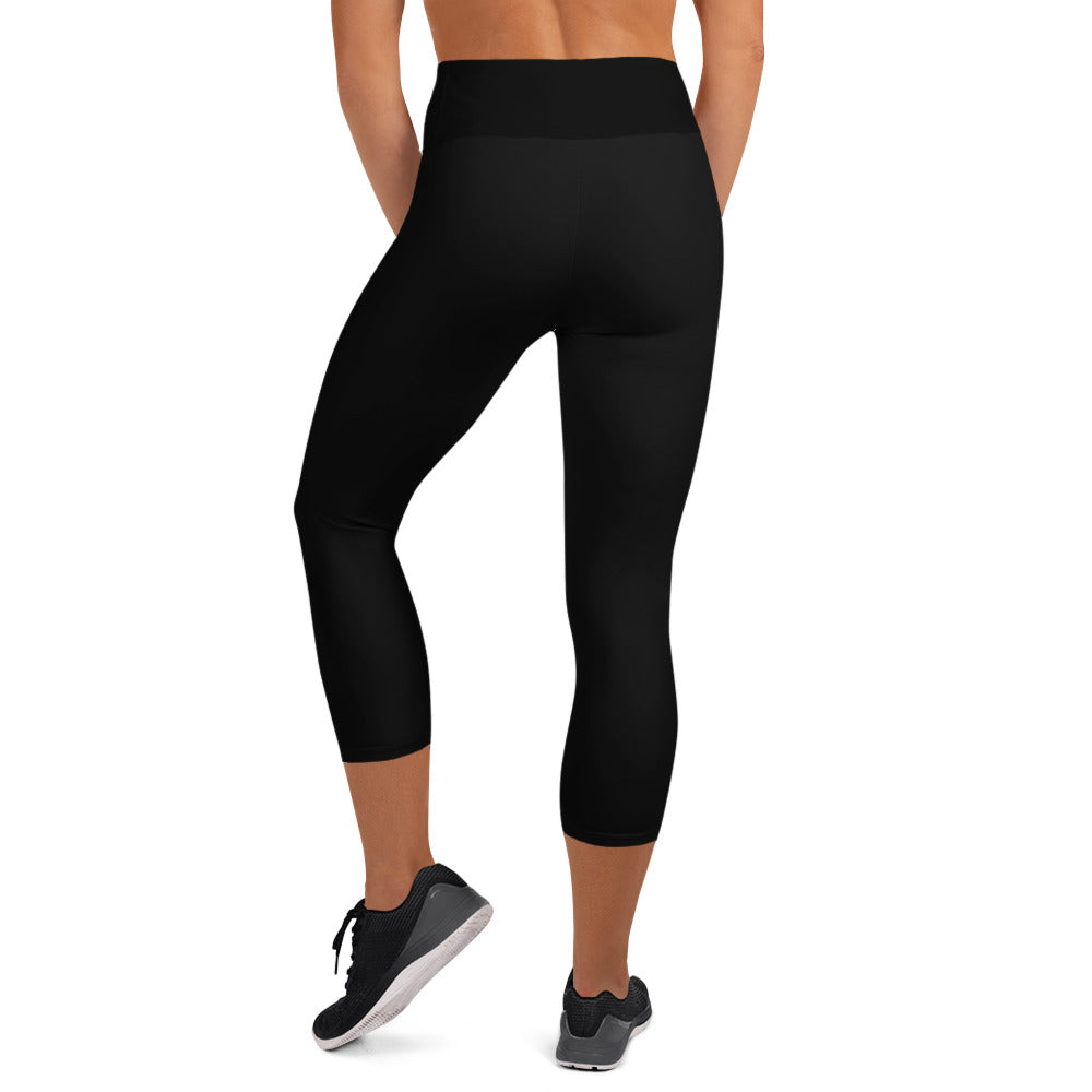 Women earing a black legging with white background in the back.