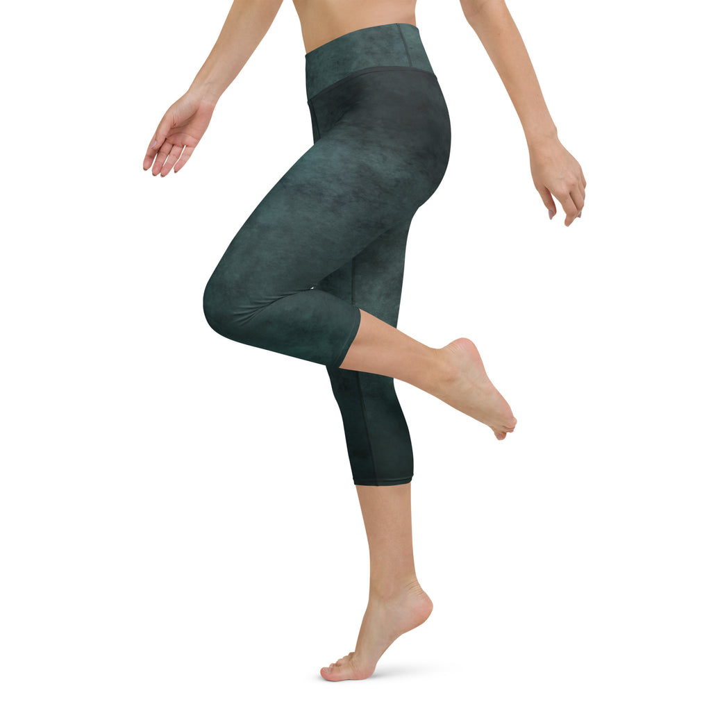 A woman wearing green capri leggings with a high-waisted fit. The leggings have a printed pattern and appear to be made of a stretchy fabric.