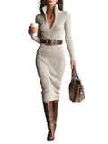 Woman in a beige ribbed dress with brown belt and boots, holding a coffee cup and handbag against a gray background.