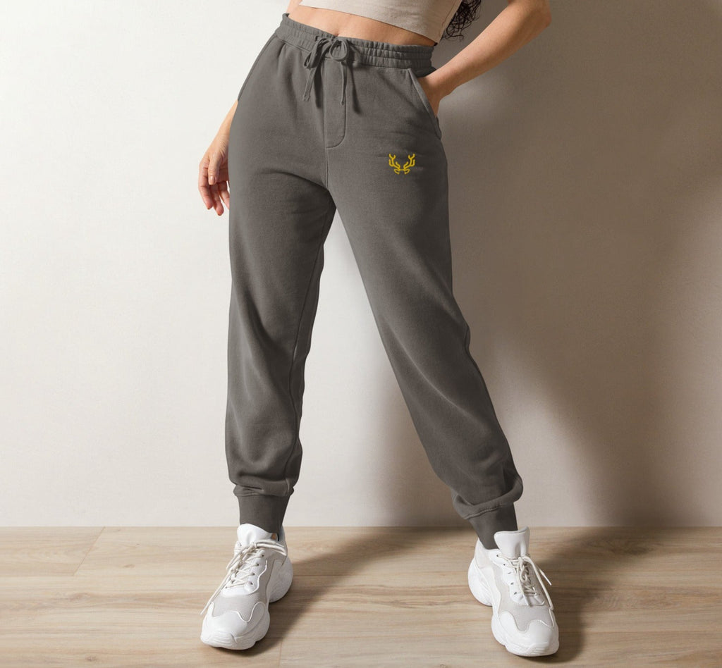 A pair of gray sweatpants with a logo on the right leg, featuring a relaxed fit with drawstrings around the waist, and a pair of white sneakers.