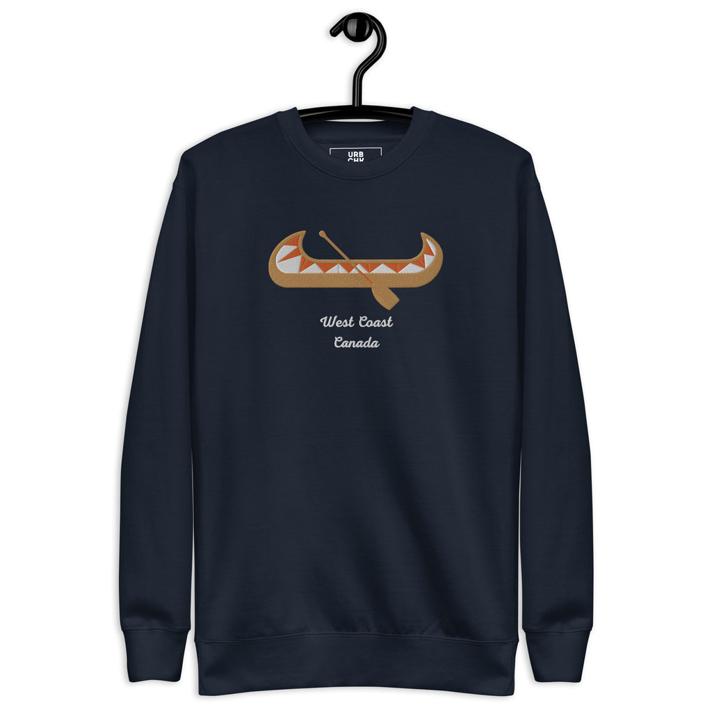 Men's navy blue sweatshirt with an embroidered design featuring a stylized bear and the text 'What Coast Canada'. Ribbed crew neck, long sleeve cuffs, and a flat hem.